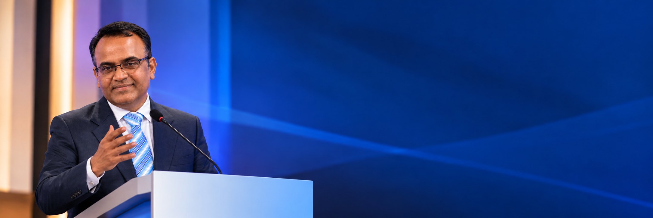 Coach Dr. Nitin Rishi speaking at a podium